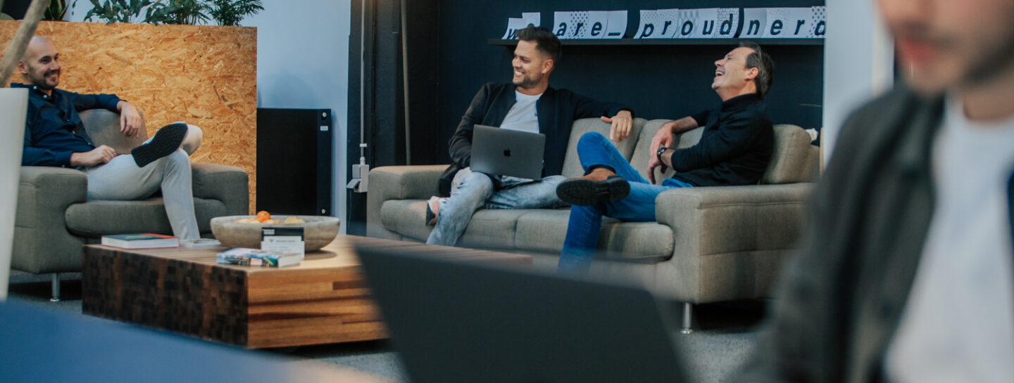 Collega’s van Proud Nerds in gesprek in een moderne kantoorruimte.