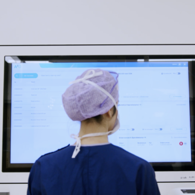 Zorgprofessional gebruikt een digitaal systeem op een touchscreen in een ziekenhuisomgeving.